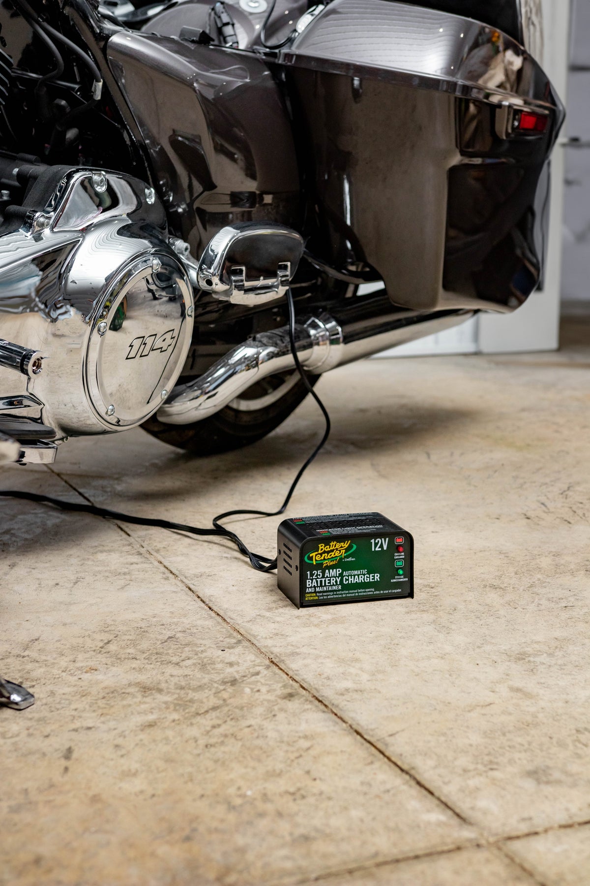 Battery Tender® motorcycle battery maintainer connected to a parked bike in a garage, ready for year-round care