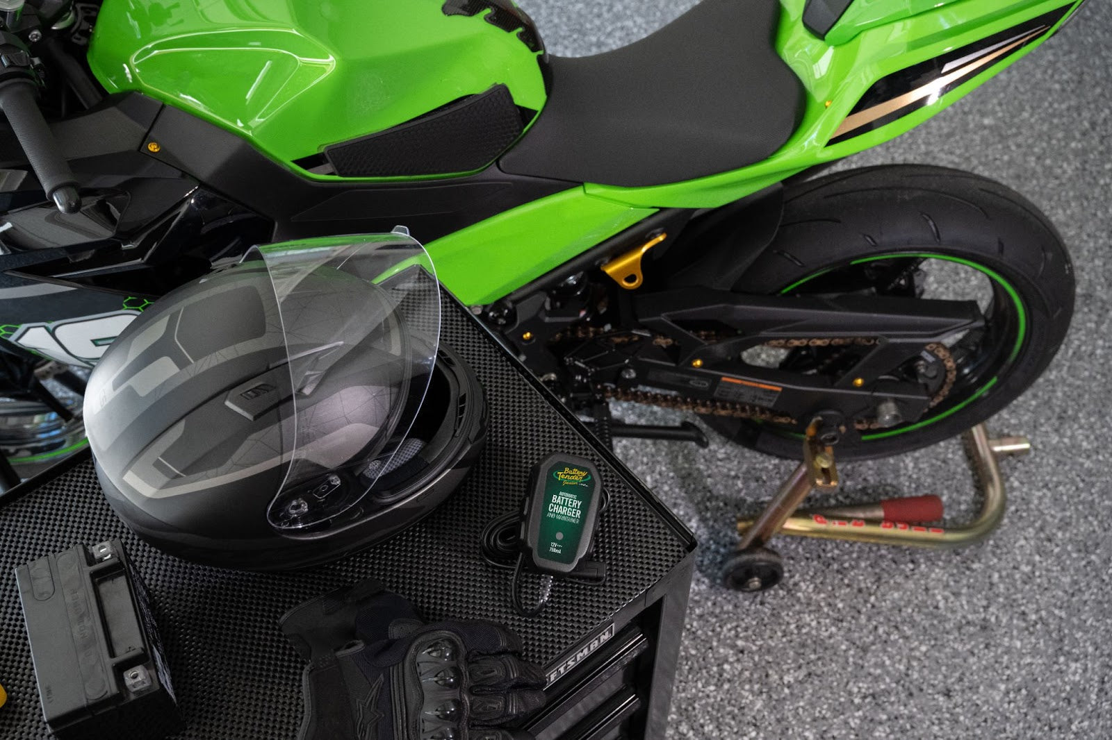 The Junior 12V Charger and Maintainer Next to Green Motorcycle